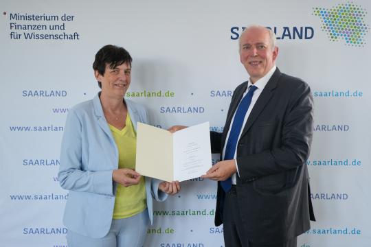 Prof. Dr. Andrea Kuhn erhält die Berufungsurkunde vom saarländischen Minister für Wissenschaft und Finanzen, Jakob von Weizsäcker. (Foto: MFW/Hey)